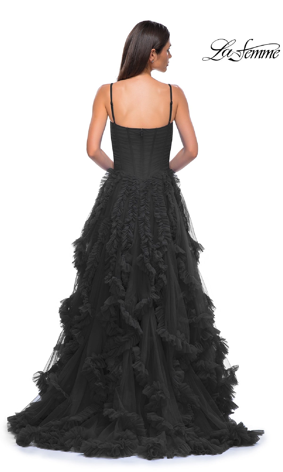 A woman is photographed from the back in a black, floor-length ruffled-tulle A-line prom ball gown with spaghetti straps (La Femme 32719), against a white background. The La Femme logo is shown in the top right corner.